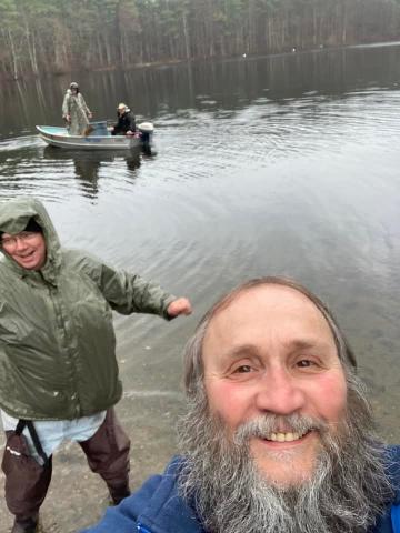 Photobomb fella in front of men stocking fish