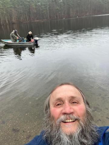 Photobomb fella in front of men stocking fish